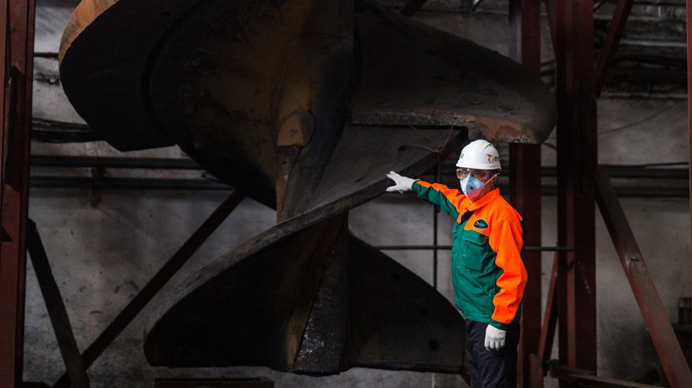Metso employee points at a Vertimill refit part that can increase longevity