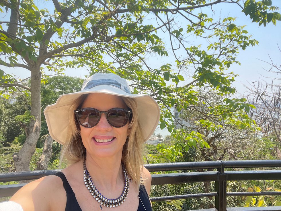 Paula Peres smiling outside under a tree.