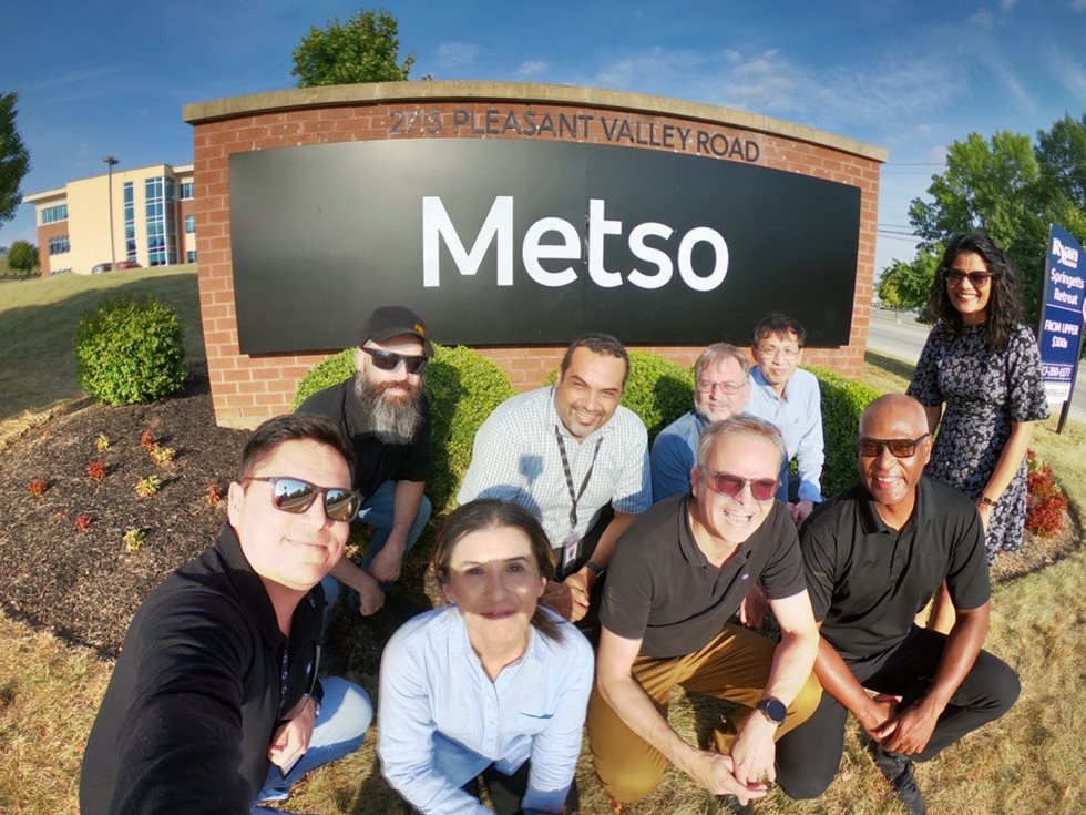 Rashmi Kasat and her team members in front of a Metso sign.
