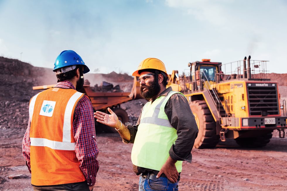Two men discussing on a Tata Steel Khodbond's mining site.